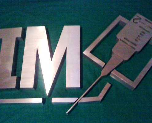 IM - Logotipo armado tipo 3D en acero inoxidable, terminado satinado mate.